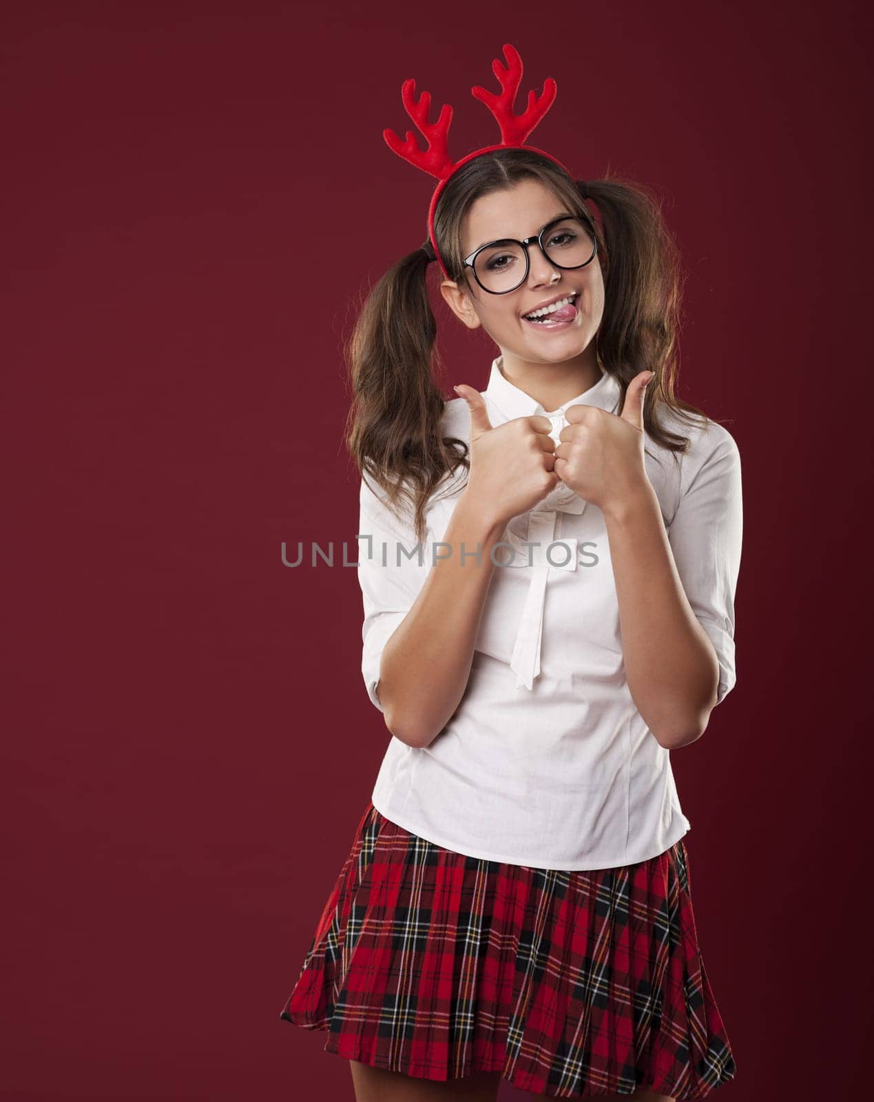 Bizarre woman with christmas horns showing thumbs up