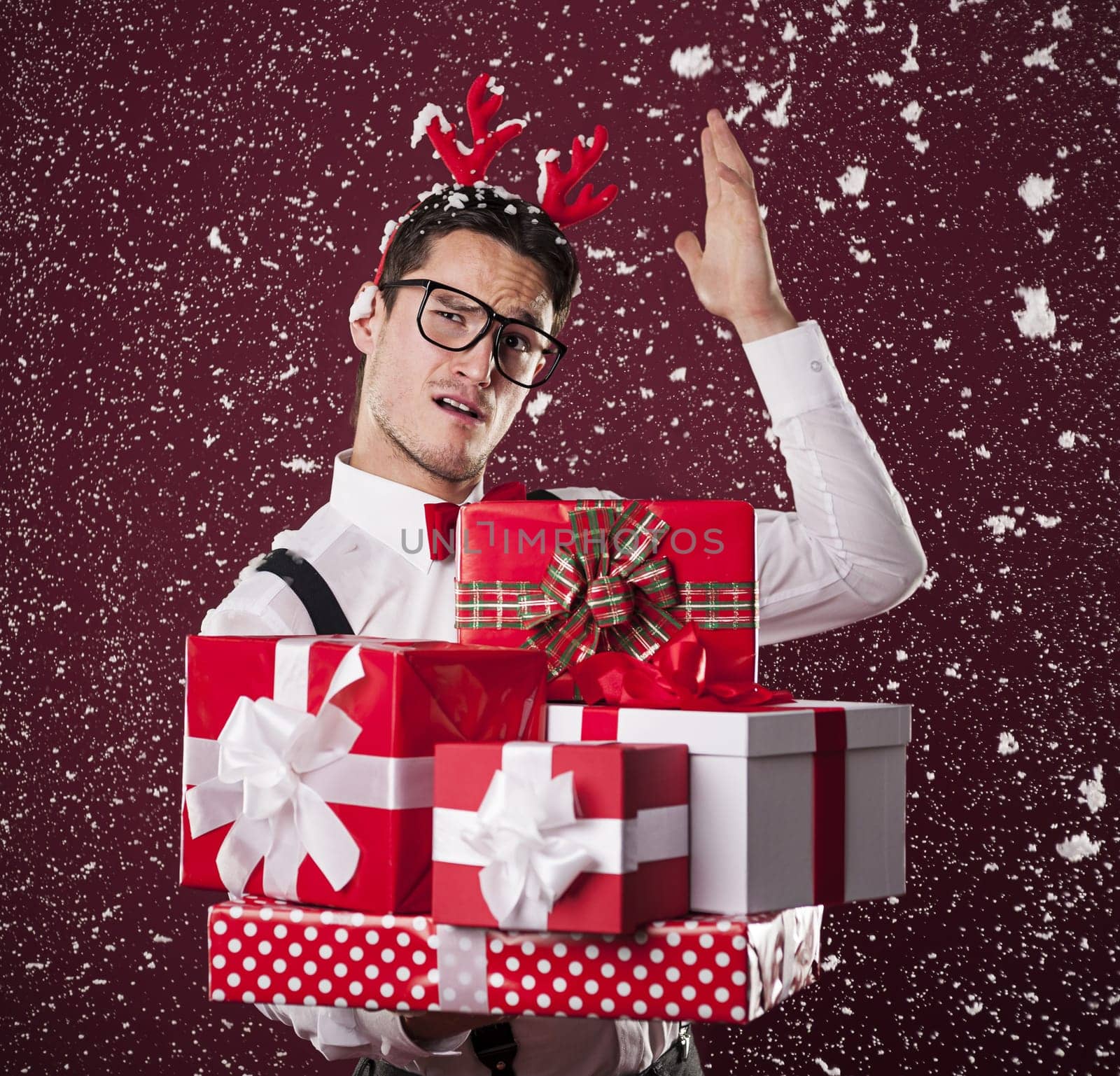 Grimacing man with stack of christmas presents