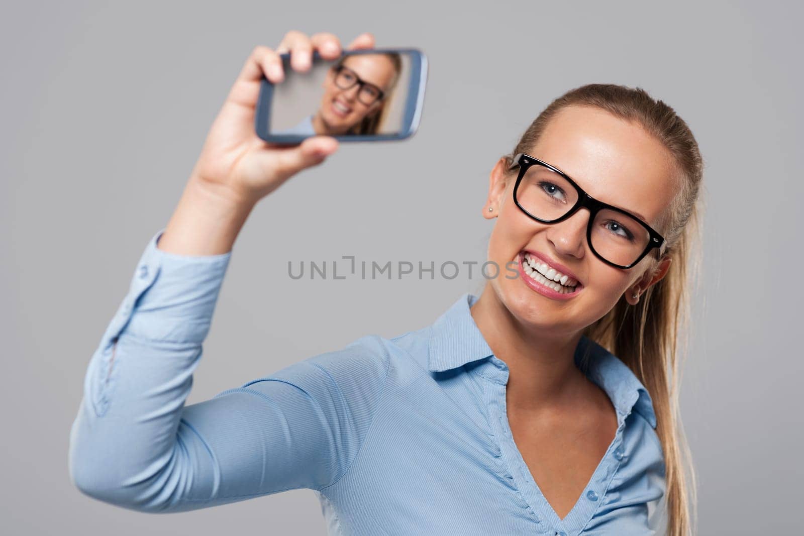 Blonde businesswoman wearing glasses taking self portrait photo