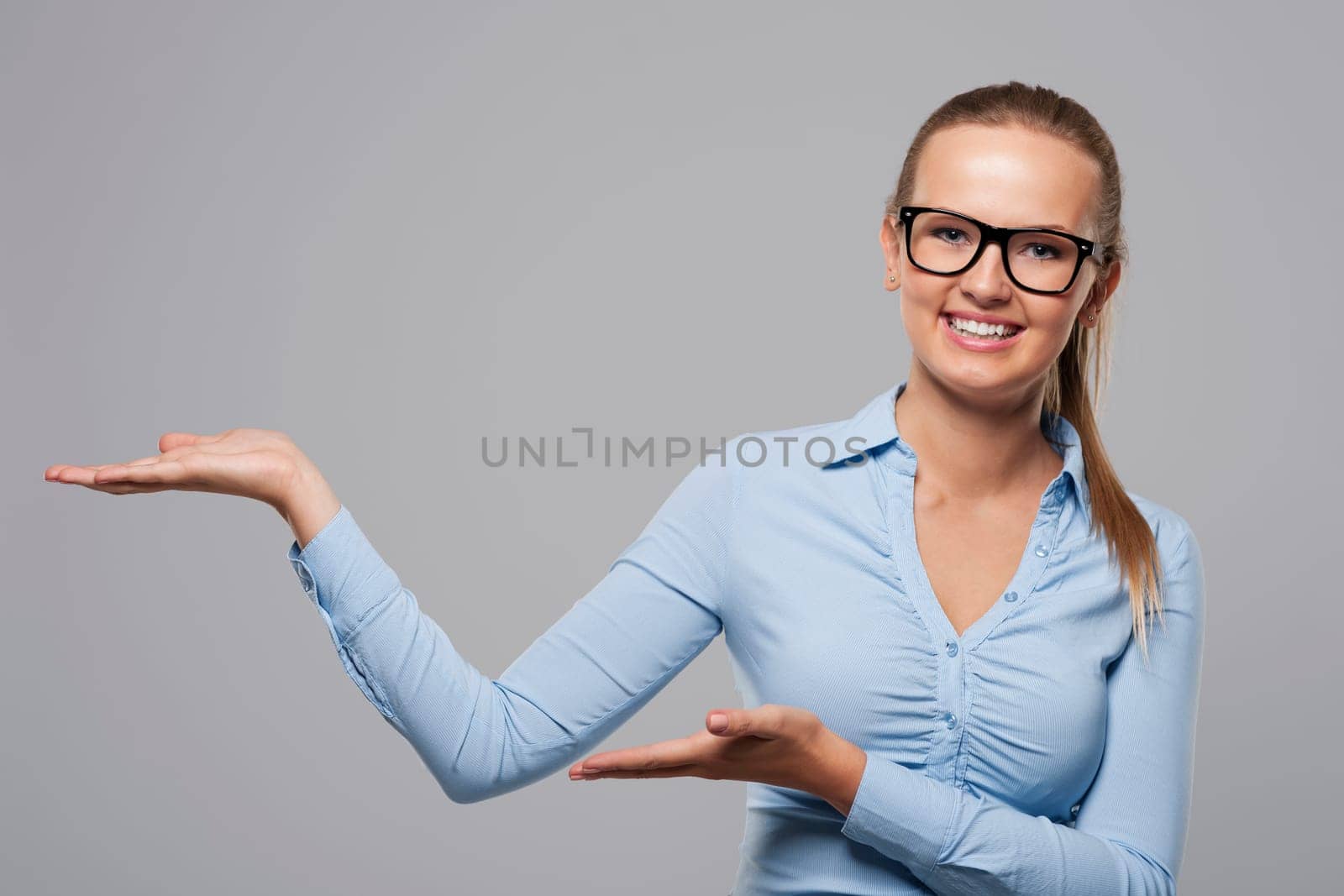 Young smiling businesswoman showing at copy space