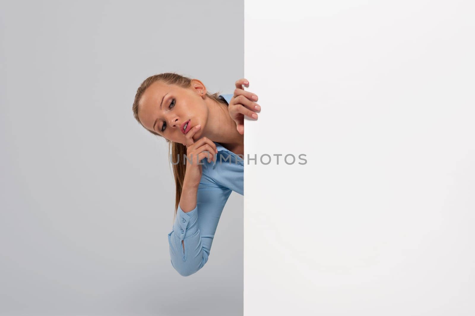 Curious businesswoman peeking at whiteboard