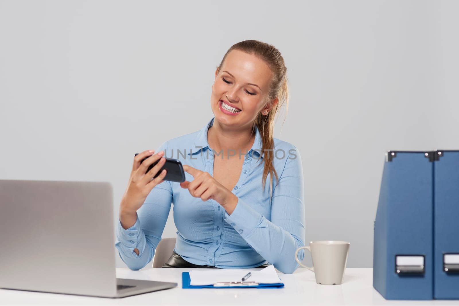 Happy woman using mobile phone during the office work