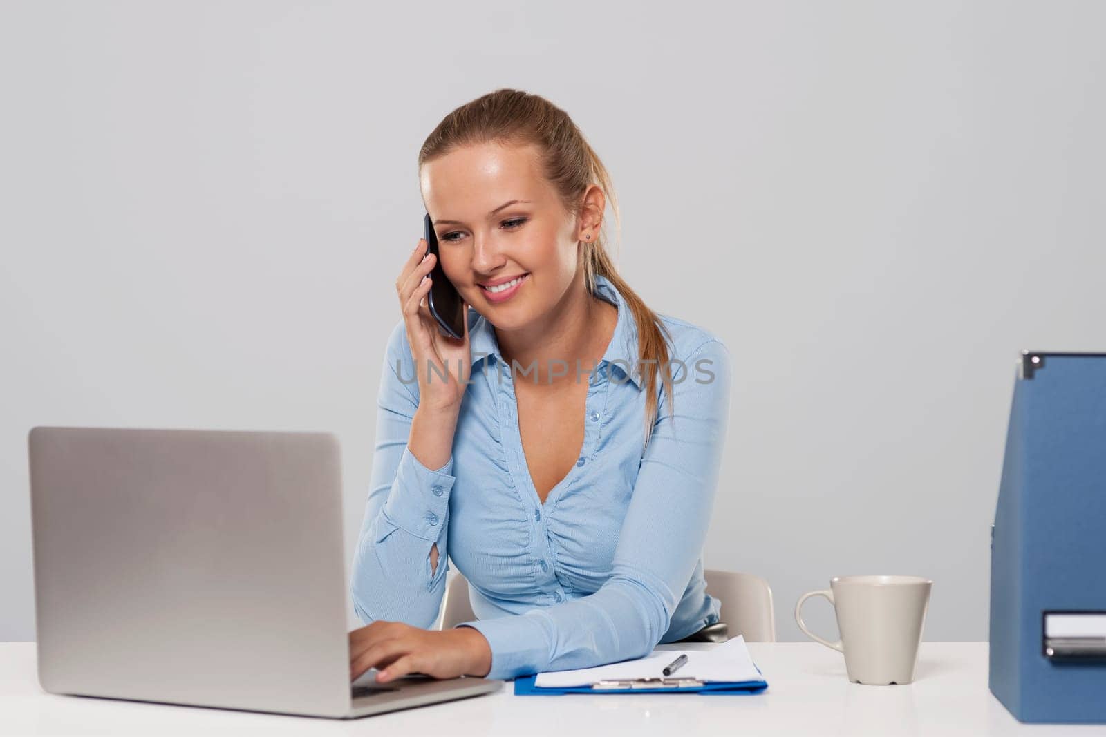 Beautiful woman talking on mobile phone during the office work