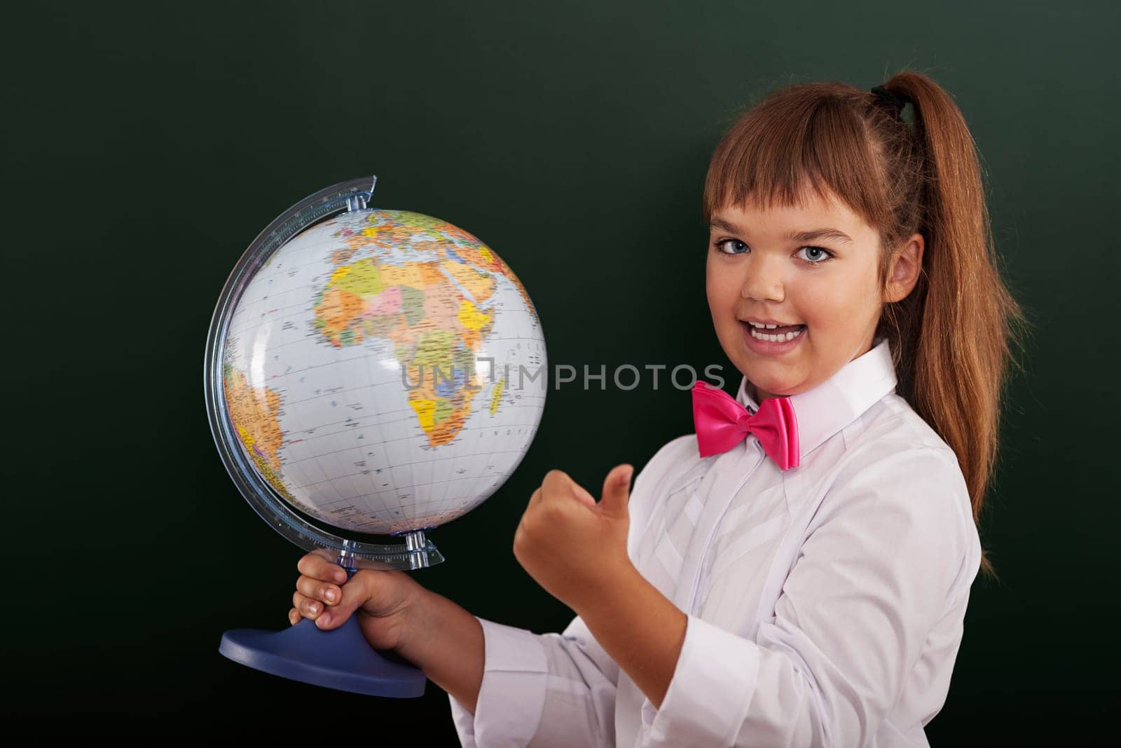 Schoolgirl with globe showing ok sign