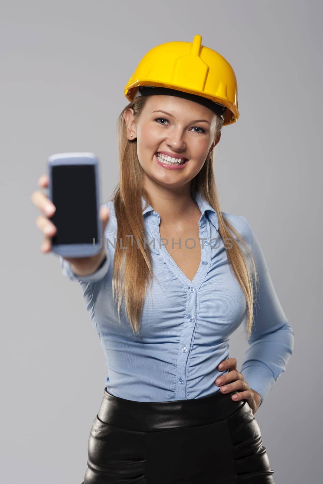 Smiling architect woman showing screen of smart phone