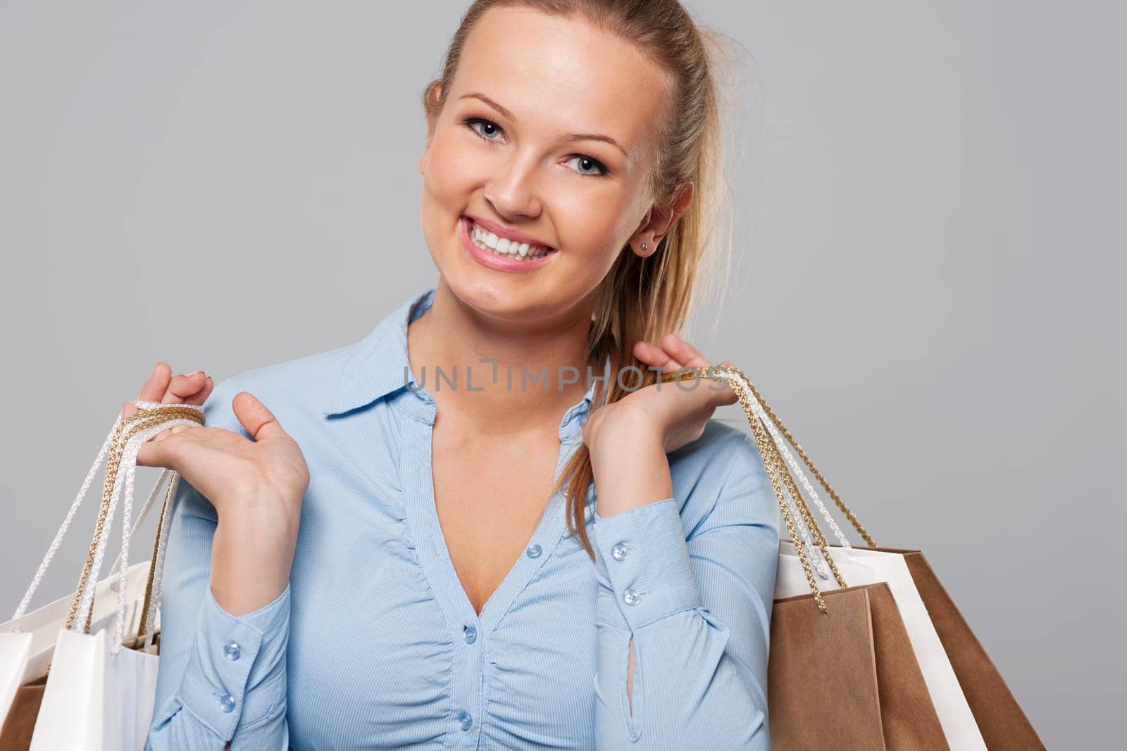 Close up of beautiful blonde woman with full of shopping bags