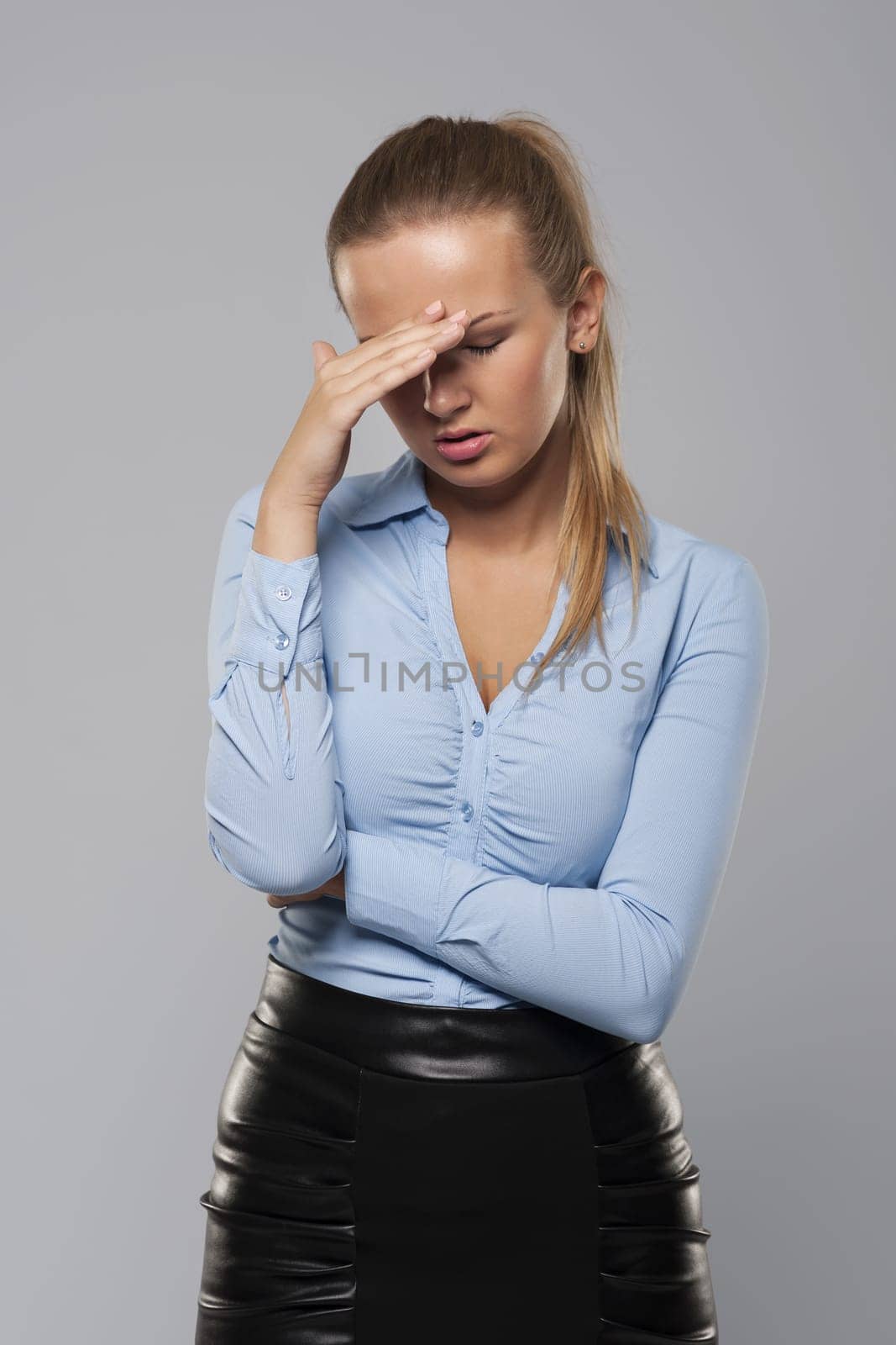 Blonde businesswoman with bad headache