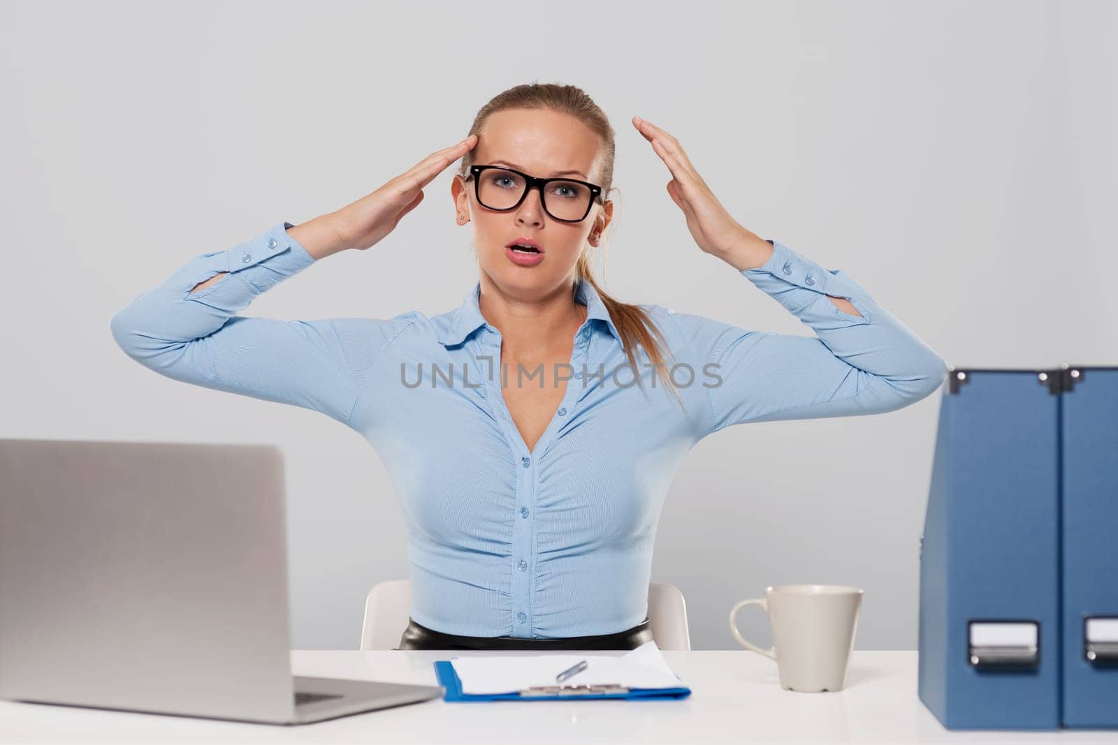 Portrait of shocked businesswoman with hands raised