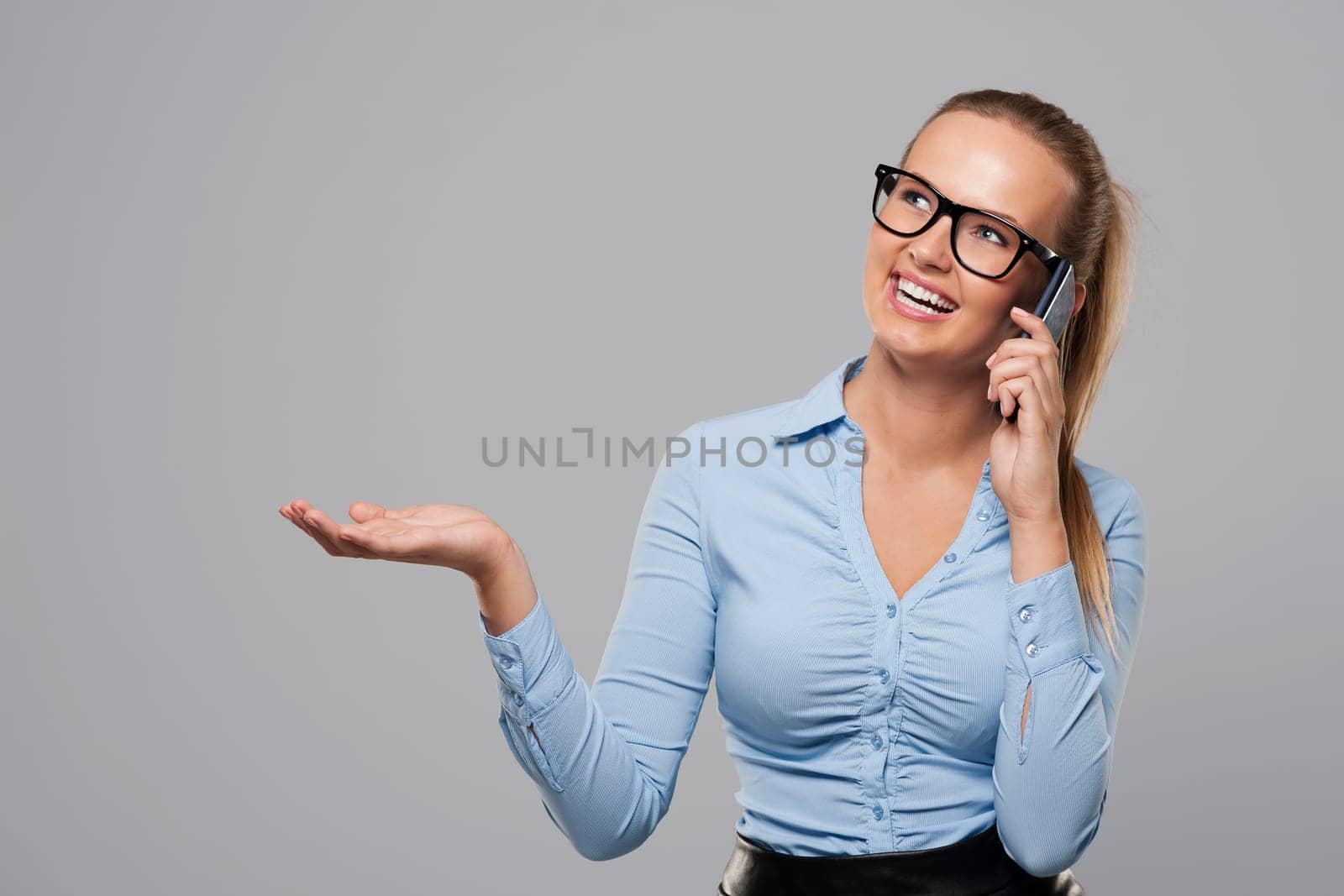 Businesswoman talking on mobile phone and showing on copy space