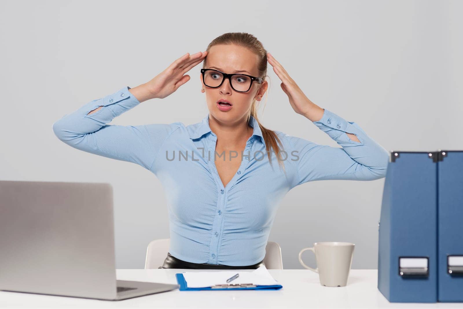 Portrait of shocked businesswoman with hands raised