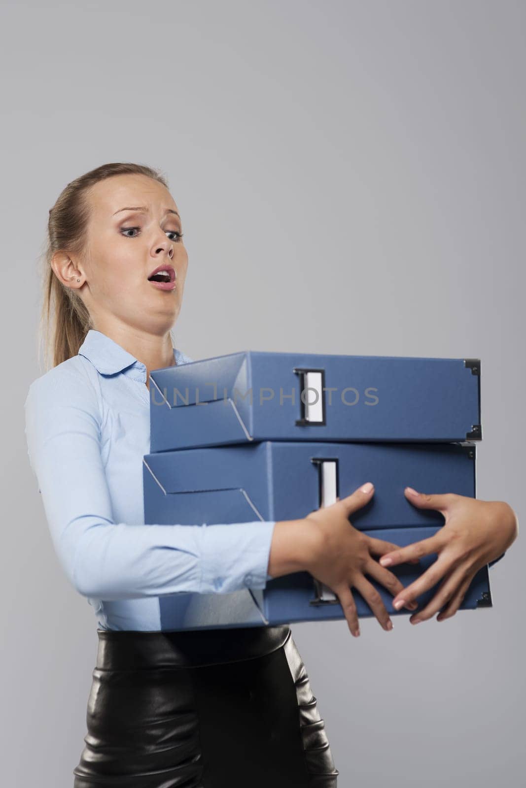 Scared businessman with heavy office documents