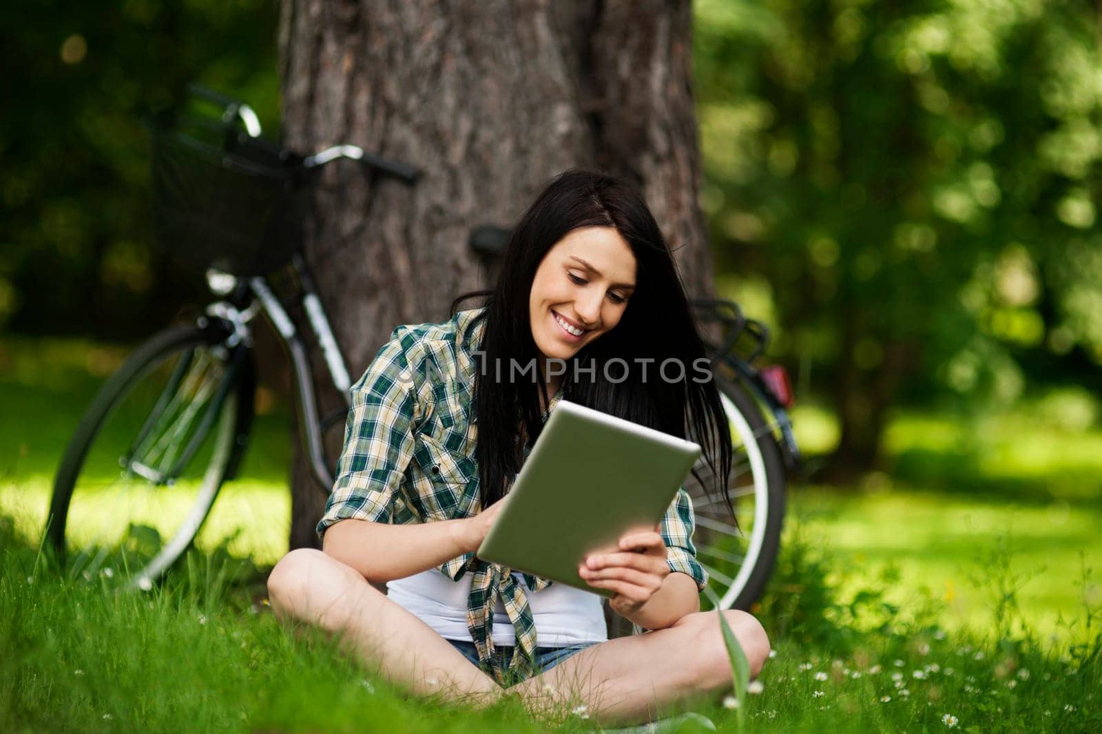 Beautiful young woman using digital tablet outdoors