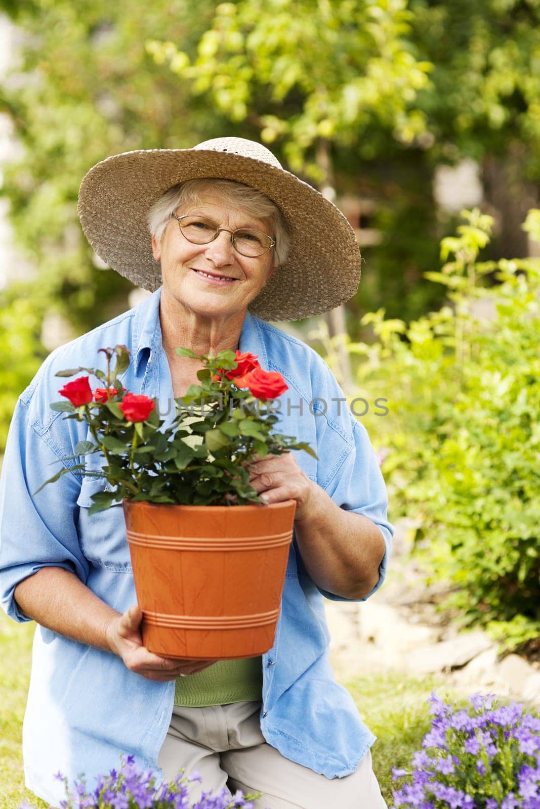 Senior woman with flowers in garden