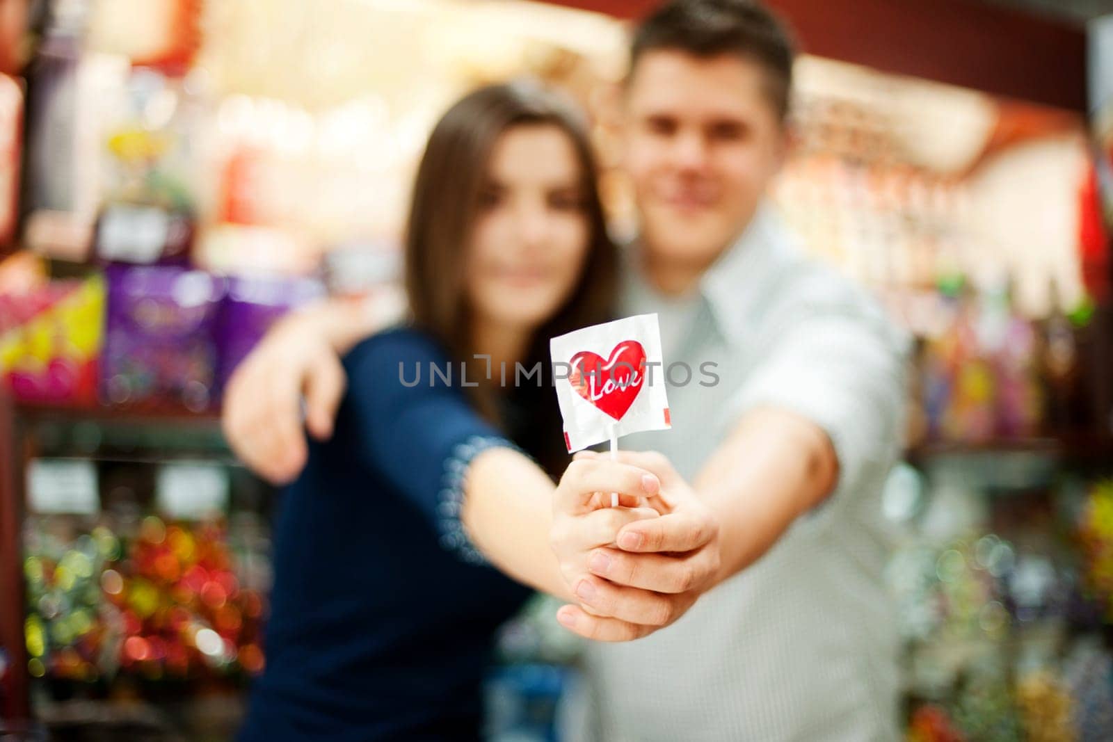 Couple holding lollipop in their hands