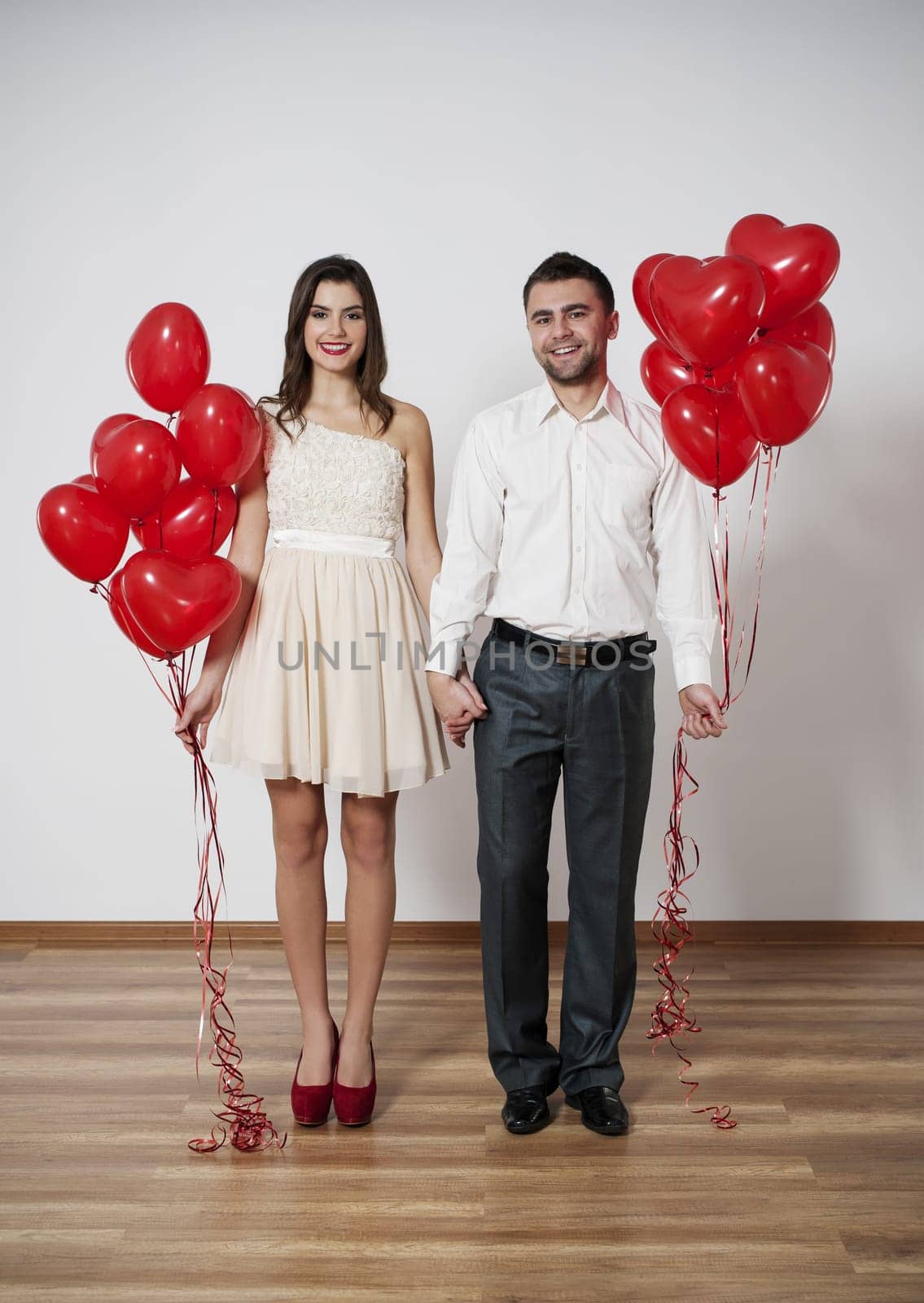 Smiling couple with balloons holding hands