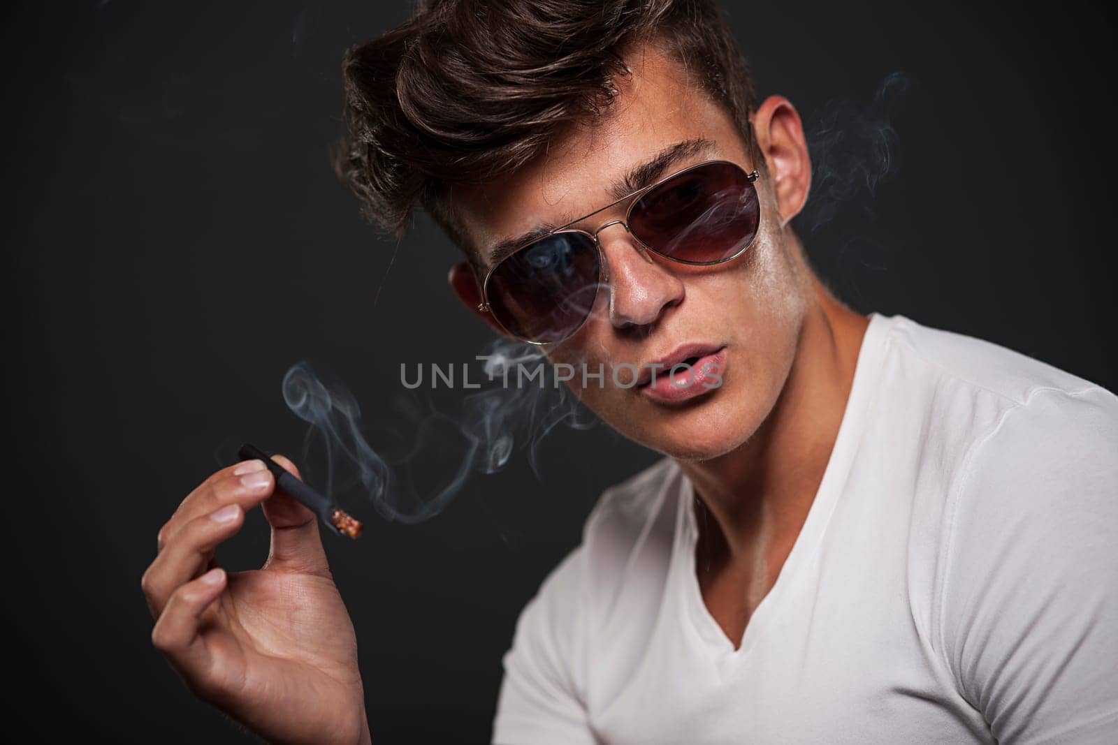 Handsome young man smoking cigarette