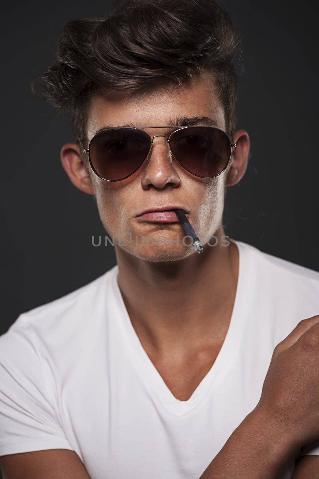 Stylish young man with cigarette between lips