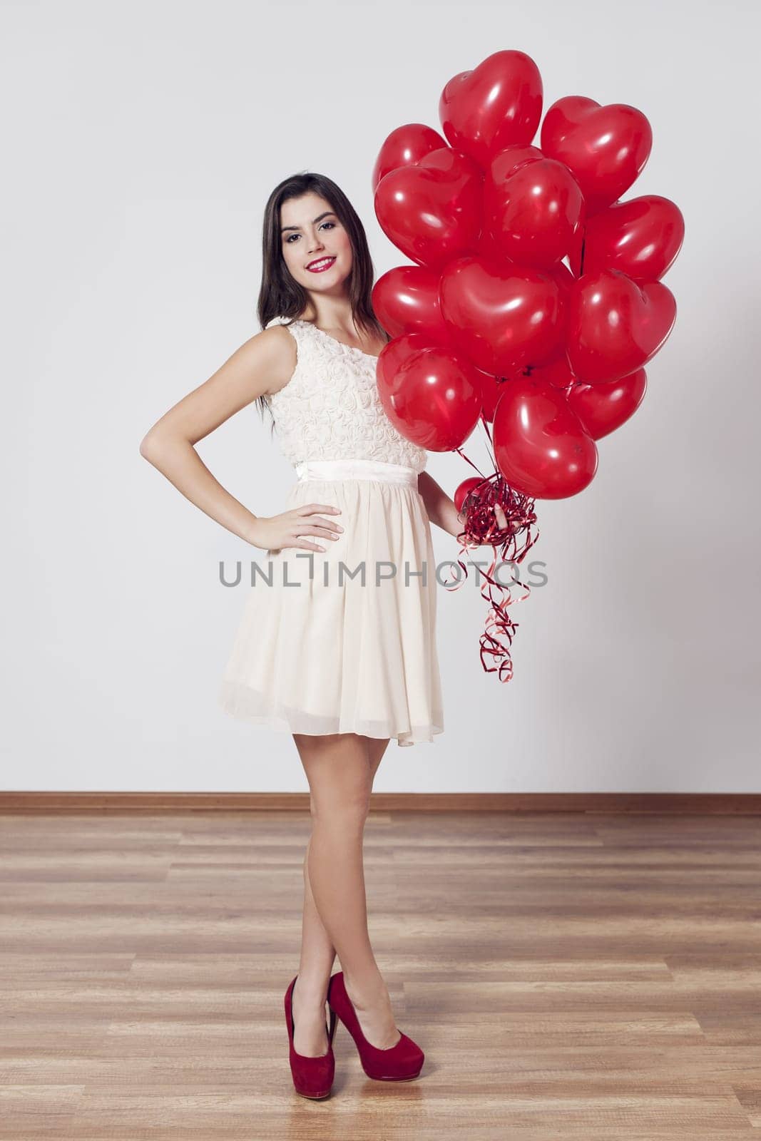 Woman holding many balloons in heart-shaped