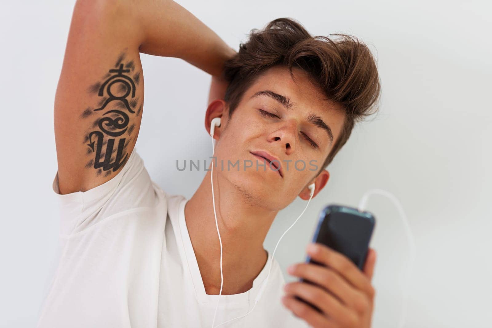 Handsome man with tattoo relaxing during listening to music