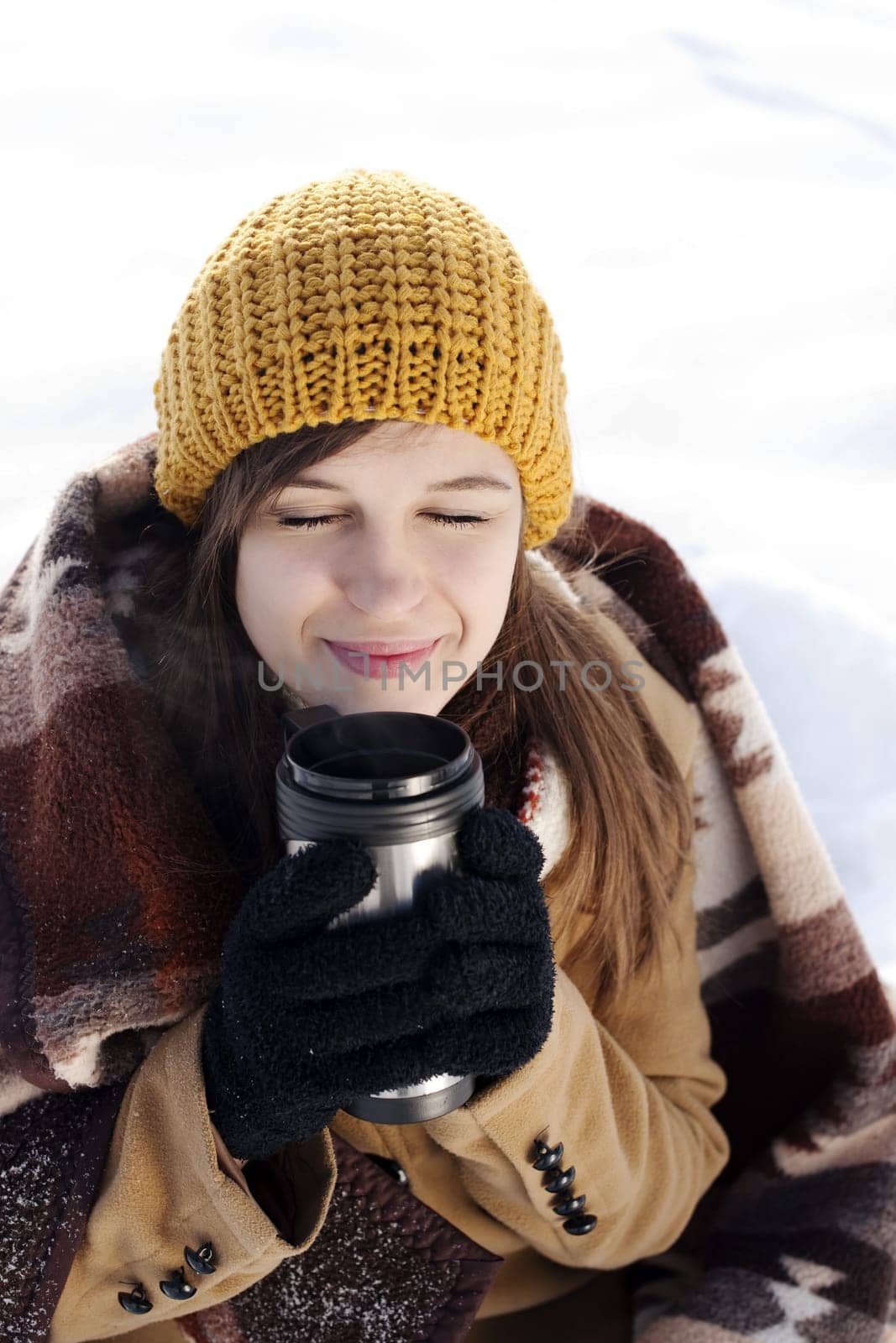 Young woman drinking hot drink outdoors