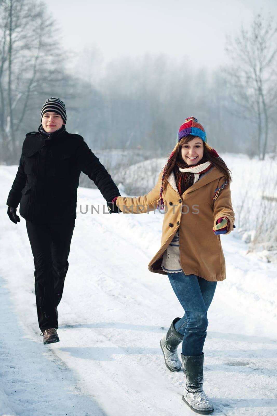 Young couple running through the park