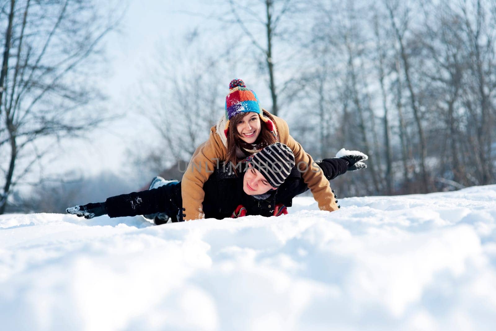 Young couple sledding on snow