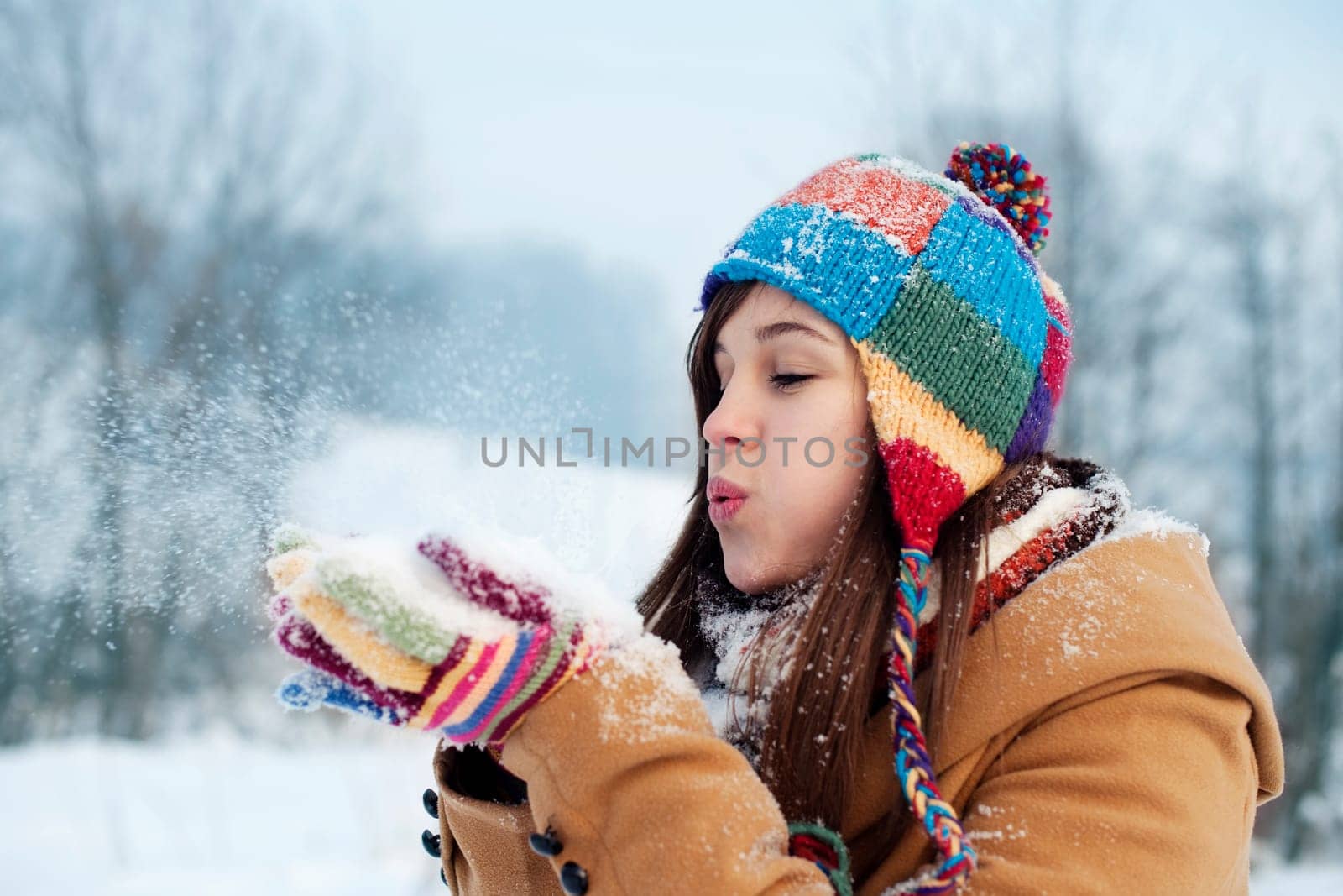 Young woman blowing snow to away
