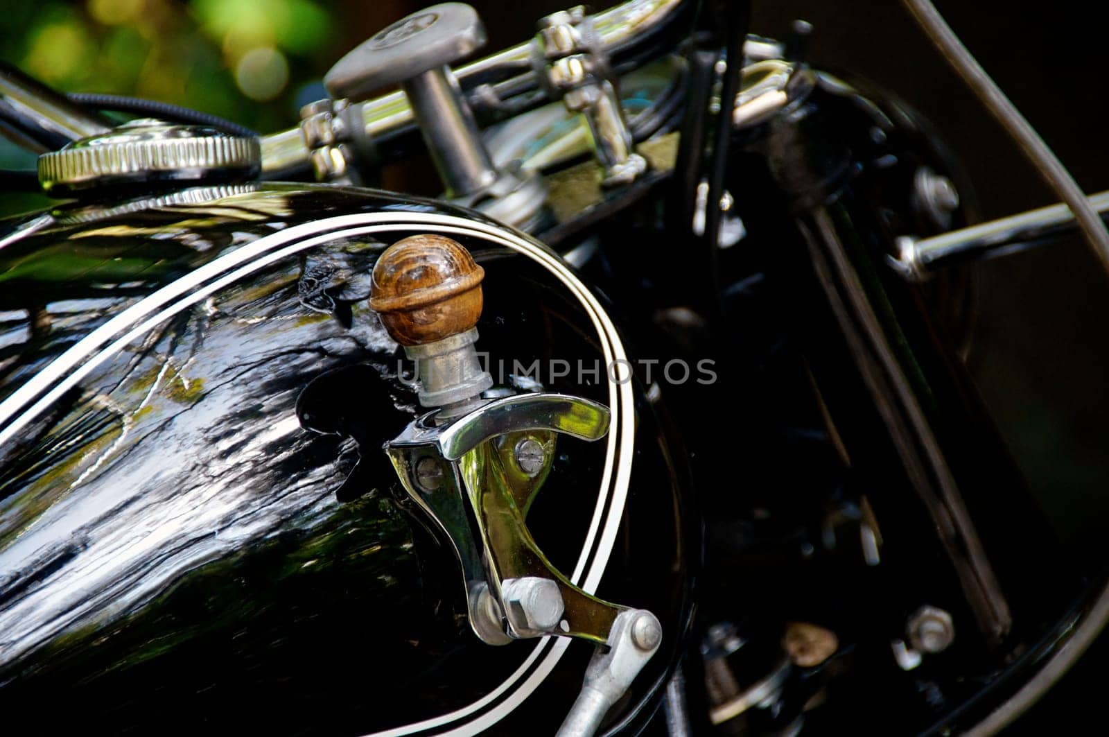 Detail of motorcycle gas tank shifter on vintage black motorcycle.