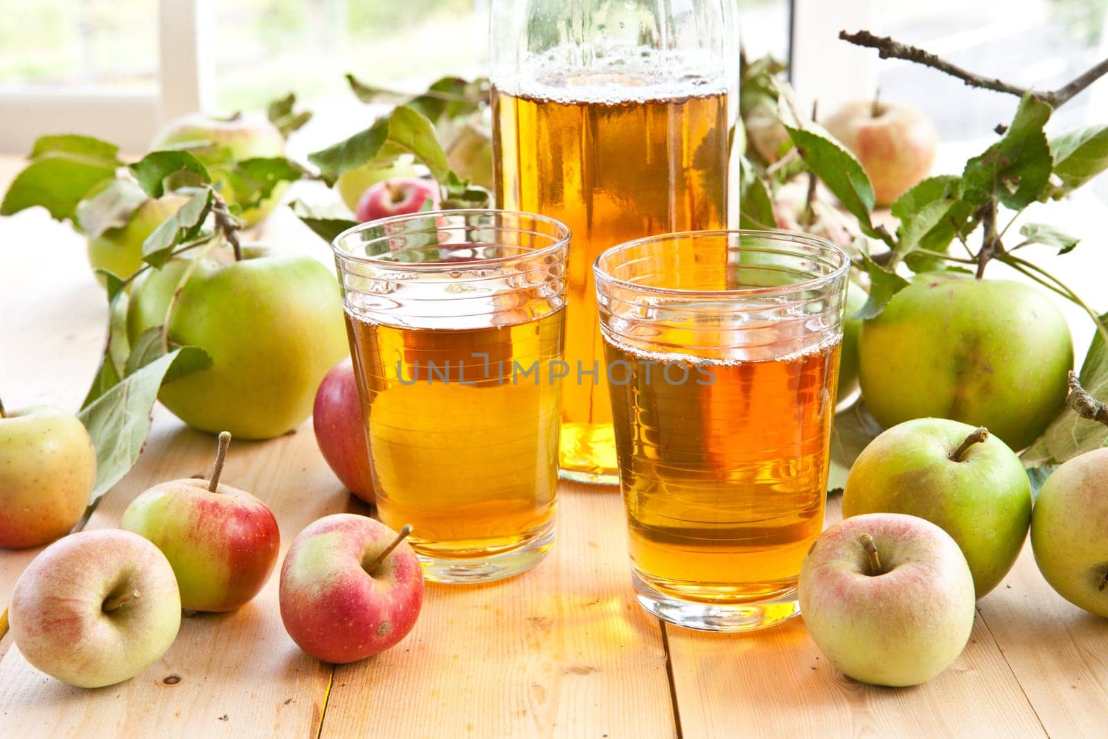 Clear apple juice in glaes with fresh apples