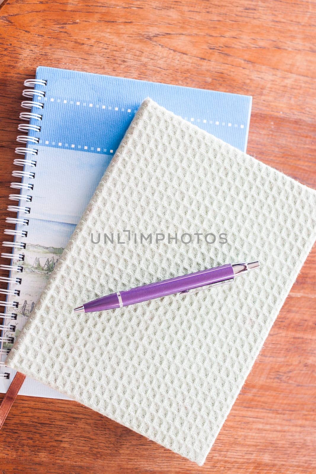 Pen and two of notebooks on wooden table, stock photo