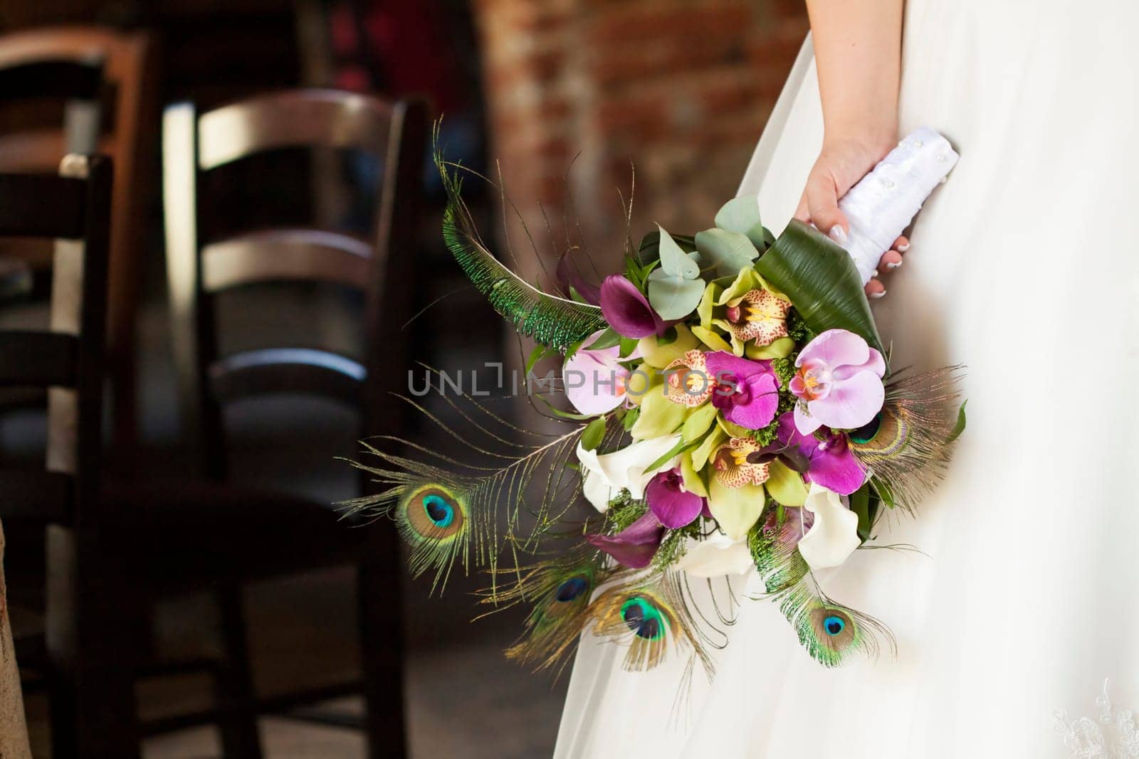 Bride holding beautiful wedding bouquet of orchid and calla