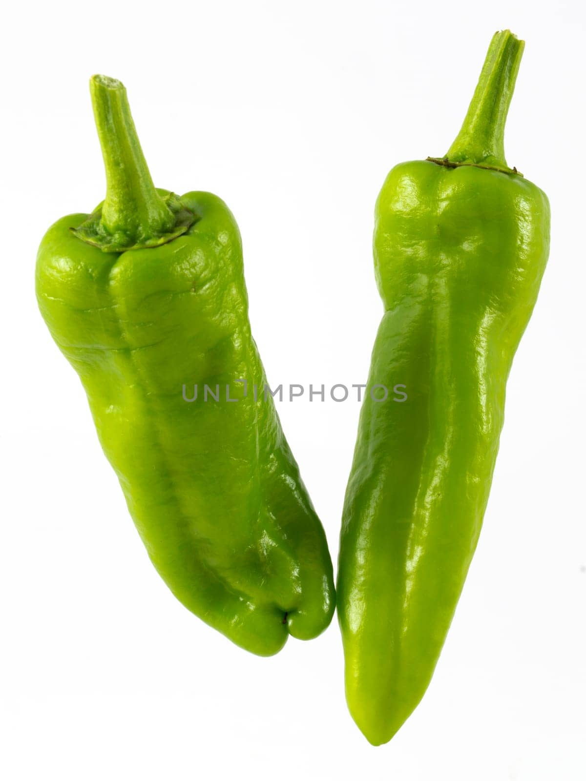 two green pepppers on white background