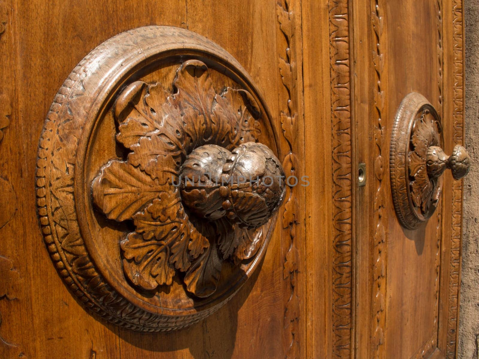 Wooden door in Arezzo in the foreground with a rosette