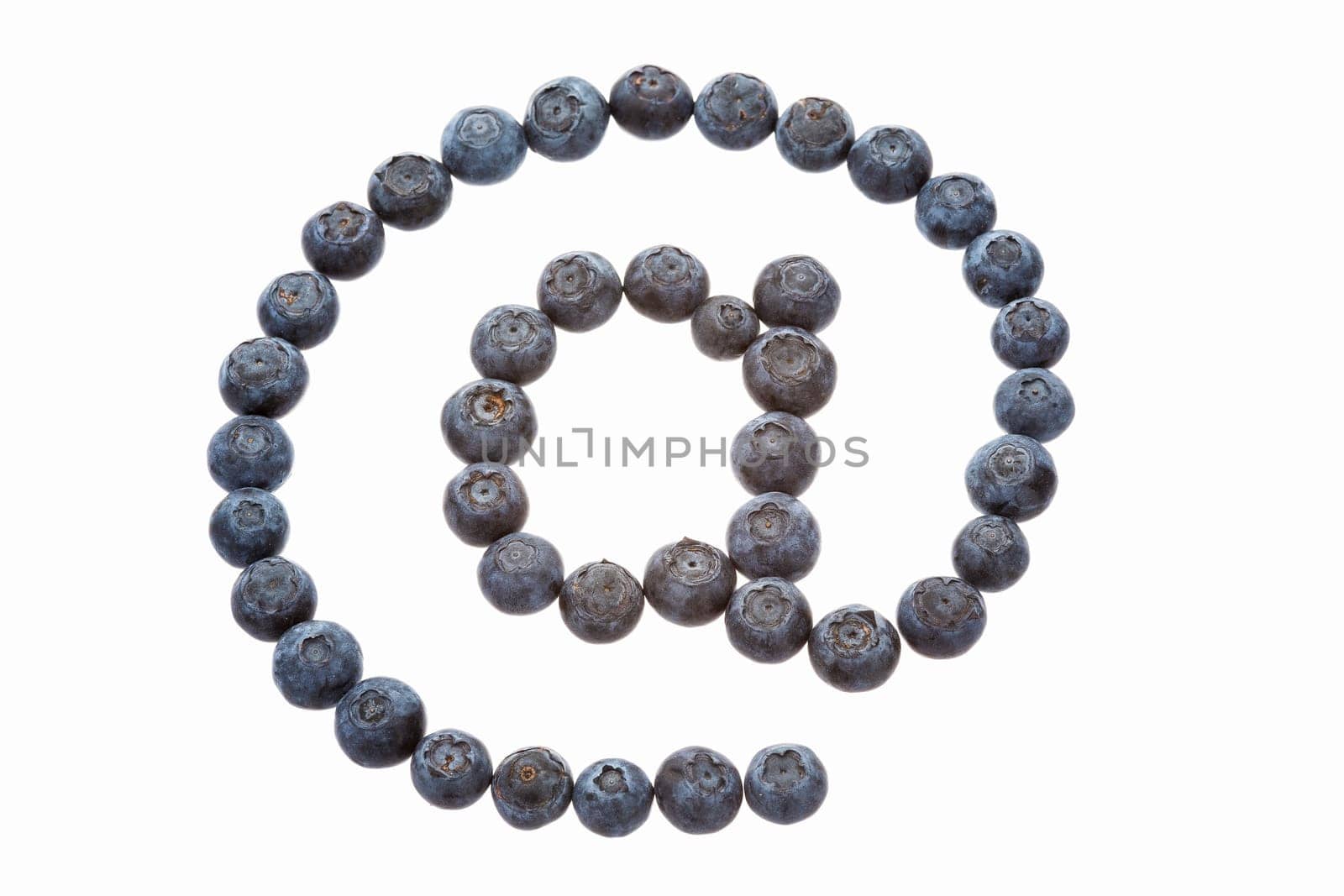 The at sign, an essential element of any email address, formed out of blueberries. It is also called at symbol, apetail or simply “At”. Das At-Zeichen, einem wesentlichen Element jeder E-Mail-Adresse, hier aus Kulturheidelbeeren geformt.