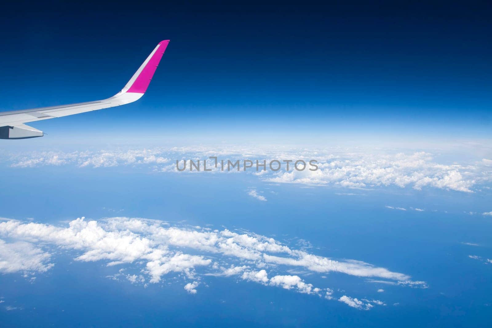 Plane wing and clouds viewed from airplane