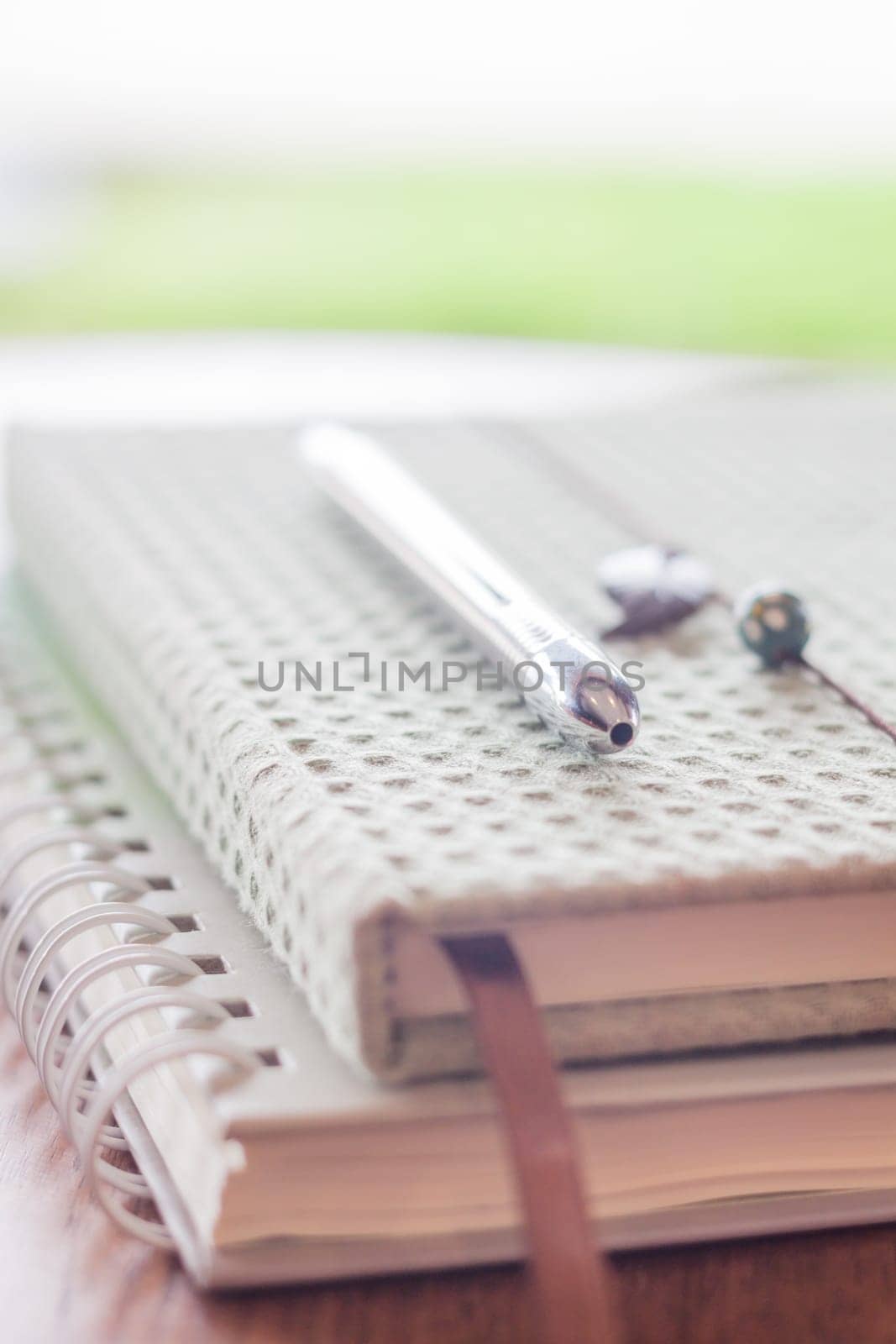 Pen on two notebooks on wooden table, stock photo