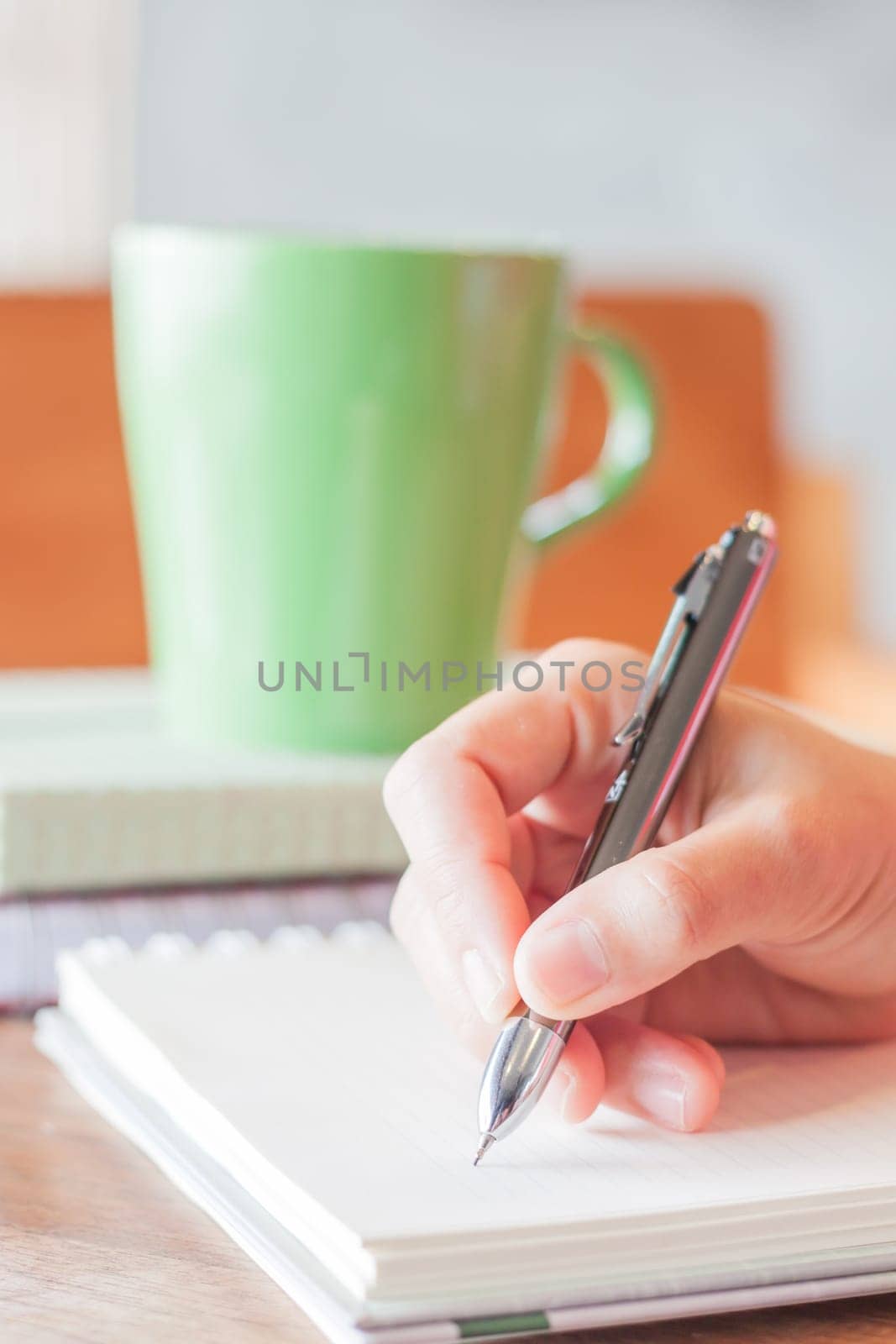 Hand writing with green mug background, stock photo