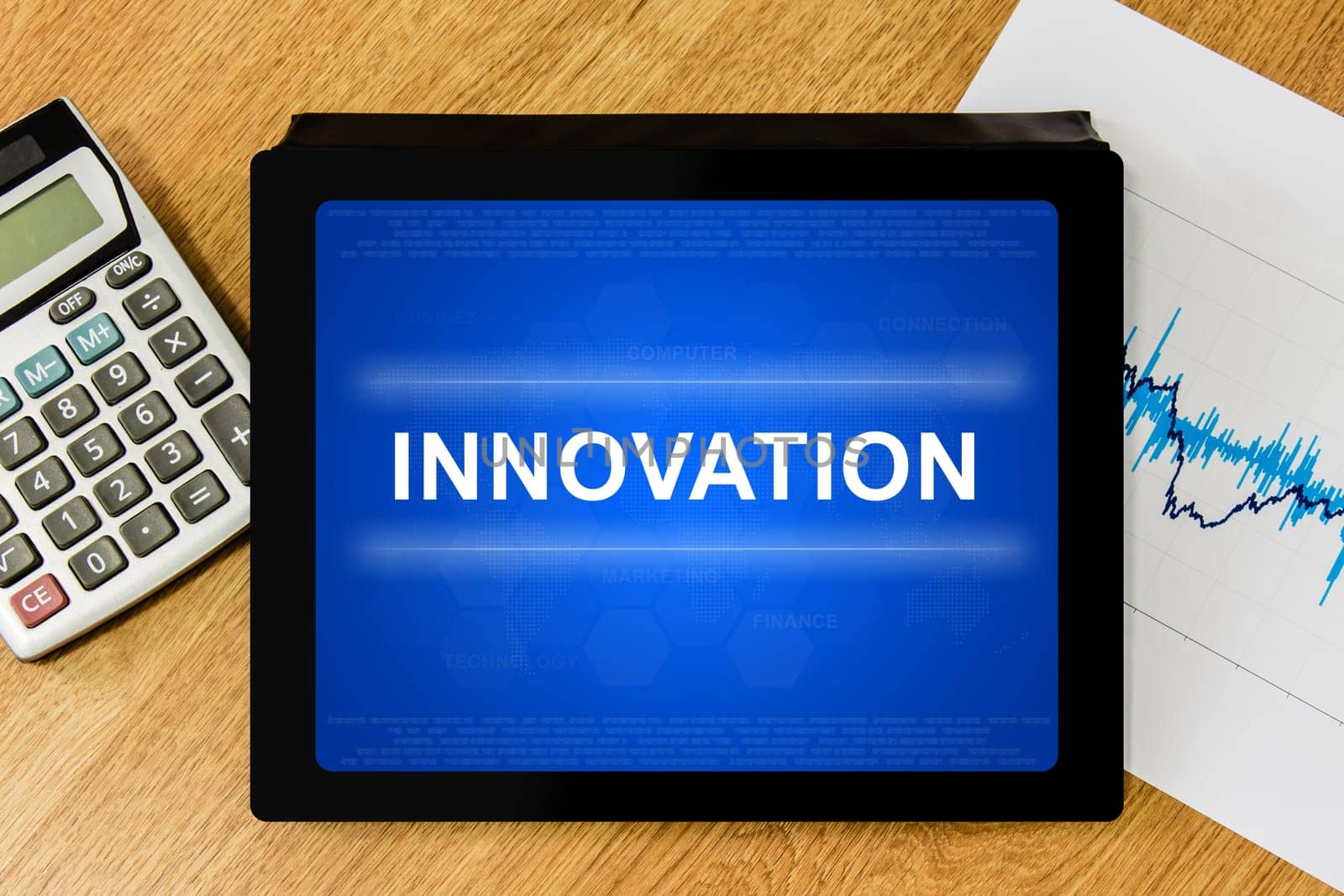 innovation word on digital tablet with calculator and financial graph