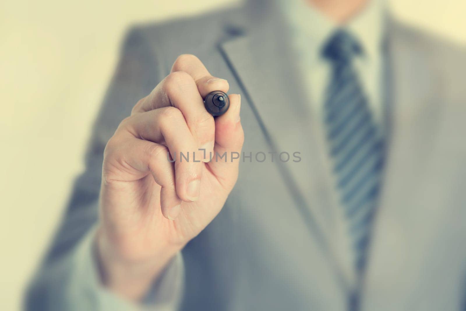 Close up businessman hand writing with marker on blank transparent screen, in vintage toned.