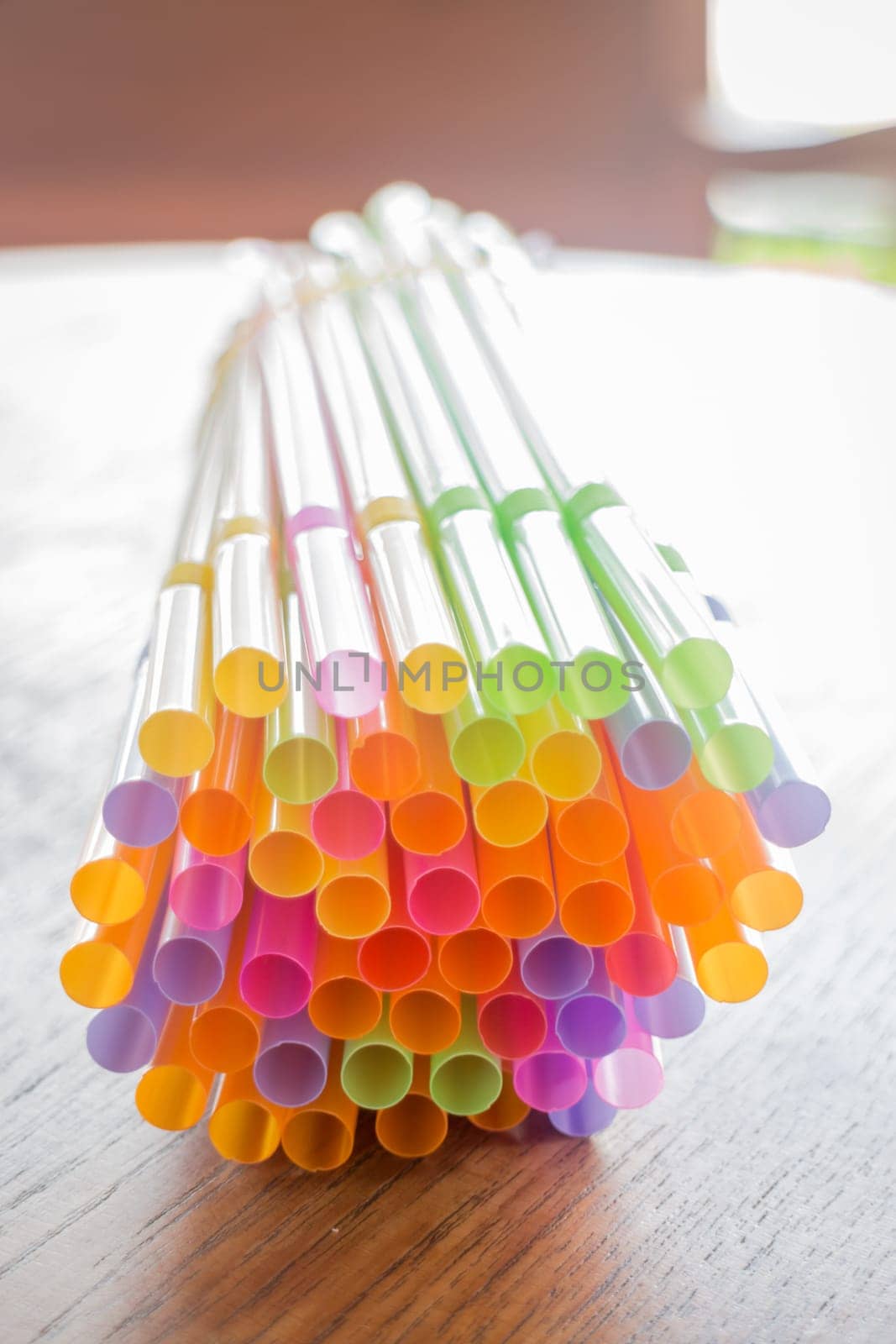 Colorful cocktail straws on wooden table, stock photo