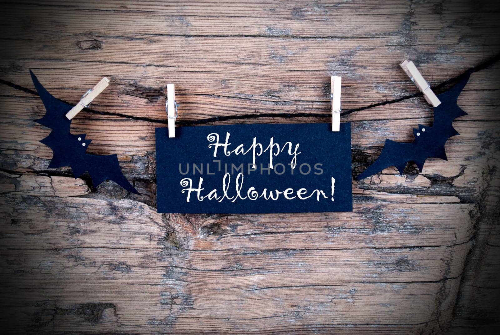 Black Label on a line with Happy Halloween on it, Wooden Background