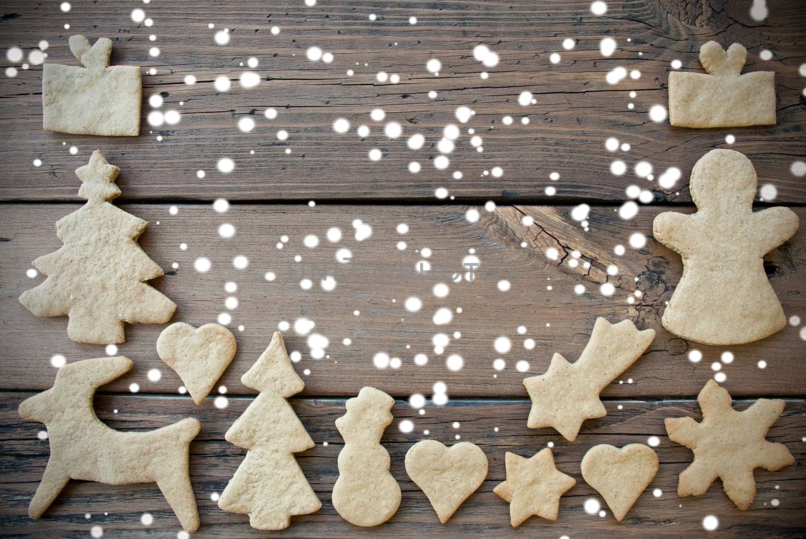 Ginger Bread Cookies as a Frame on Wood with Snow and Copy Space, Christmas or Winter Background with Free Space