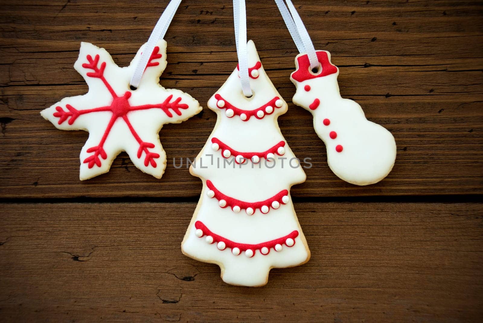 Christmas Cookies in Red and White Hanging on Wood, Closeup as Christmas or Winter Background