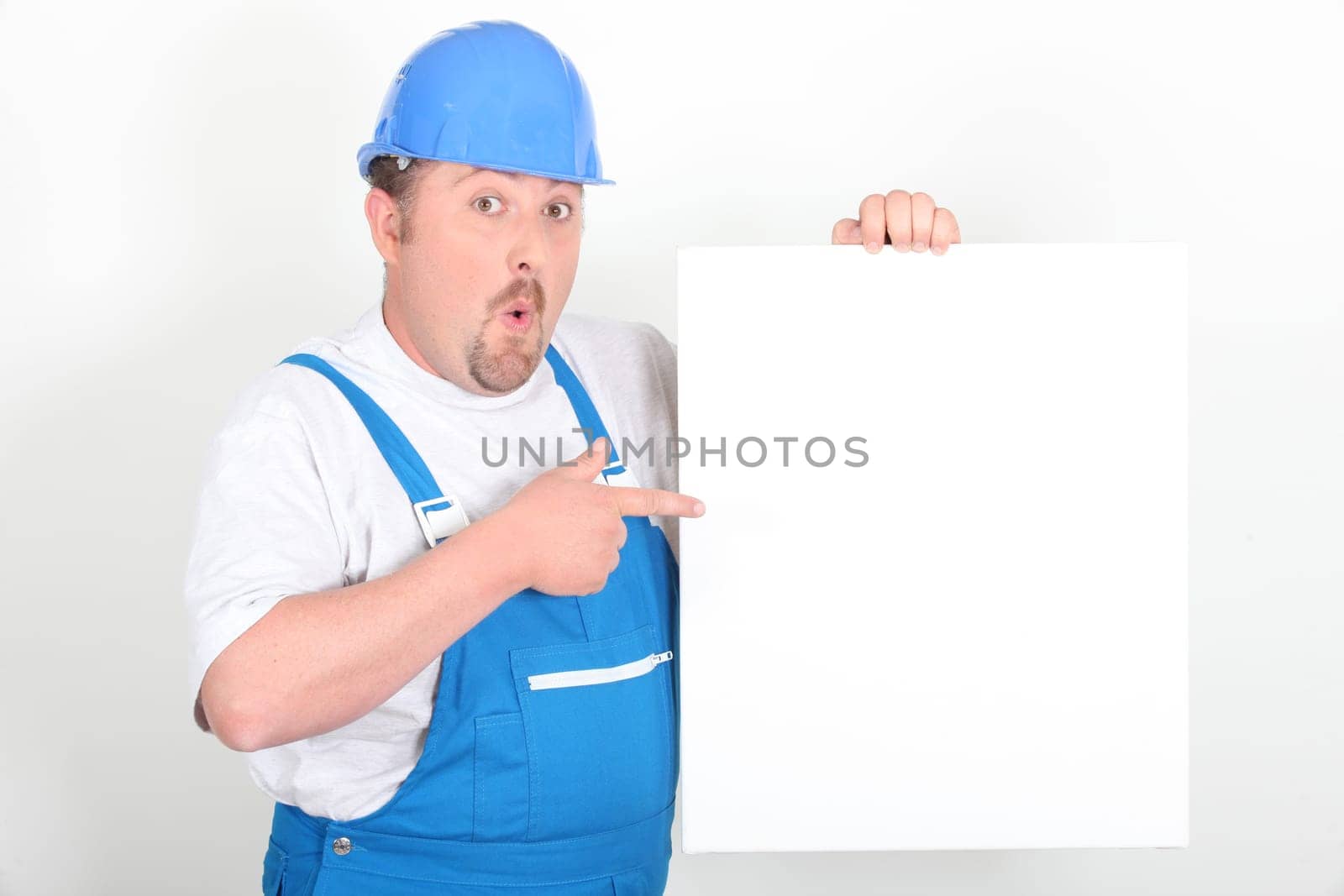 Surprised tradesman holding a blank sign