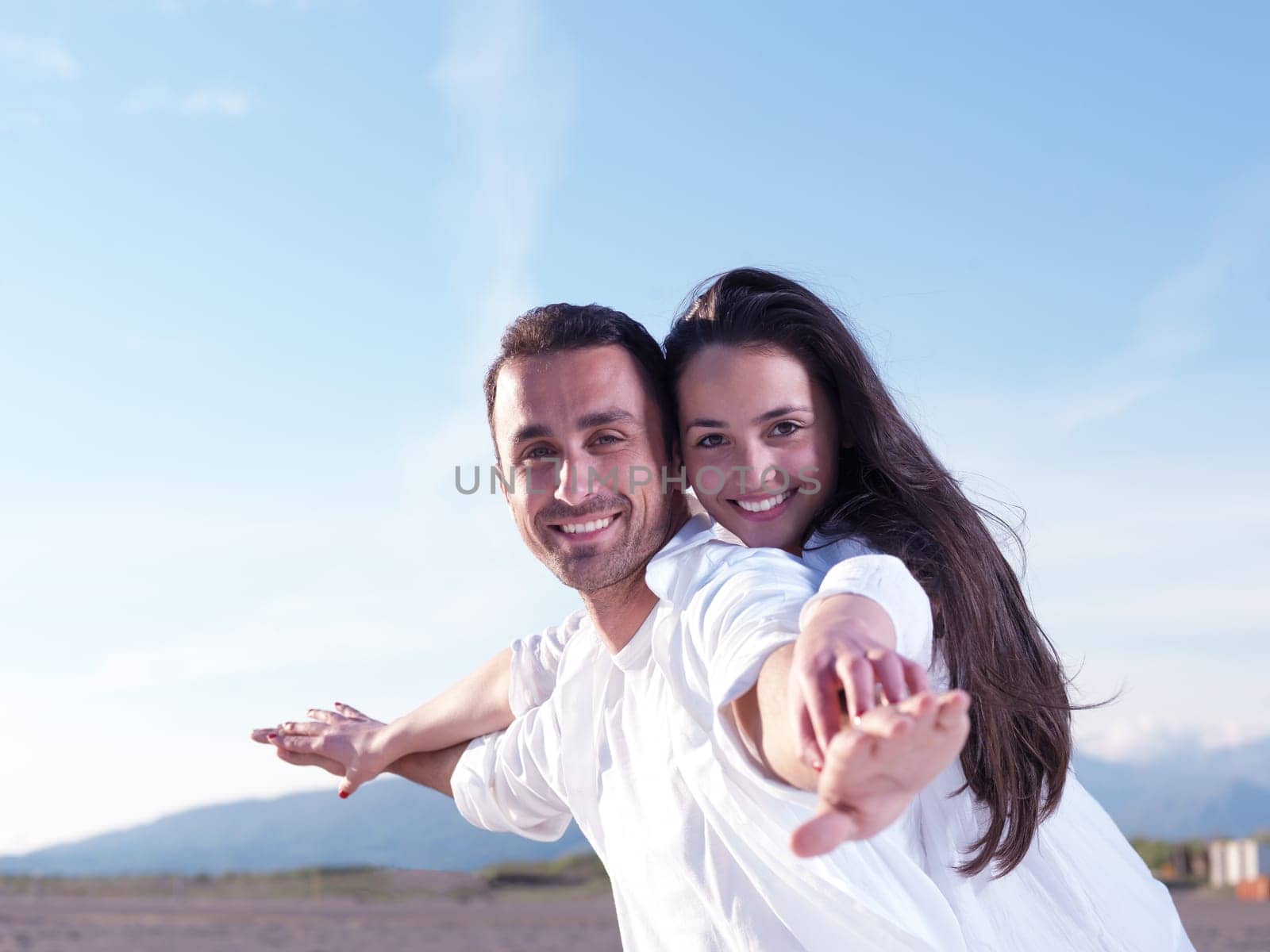 happy young romantic couple in love have fun on beautiful beach at beautiful summer day