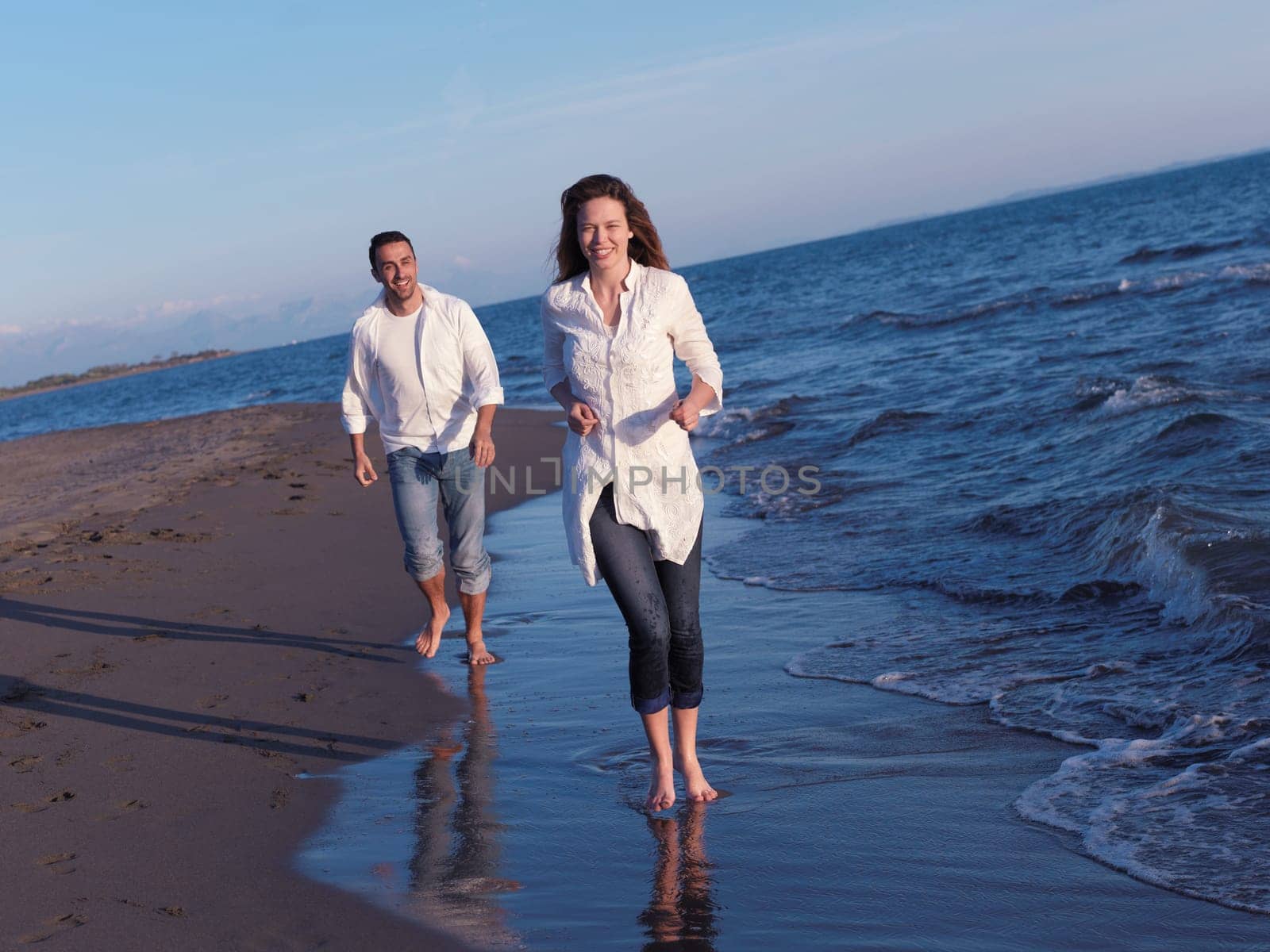 happy young romantic couple in love have fun on beautiful beach at beautiful summer day