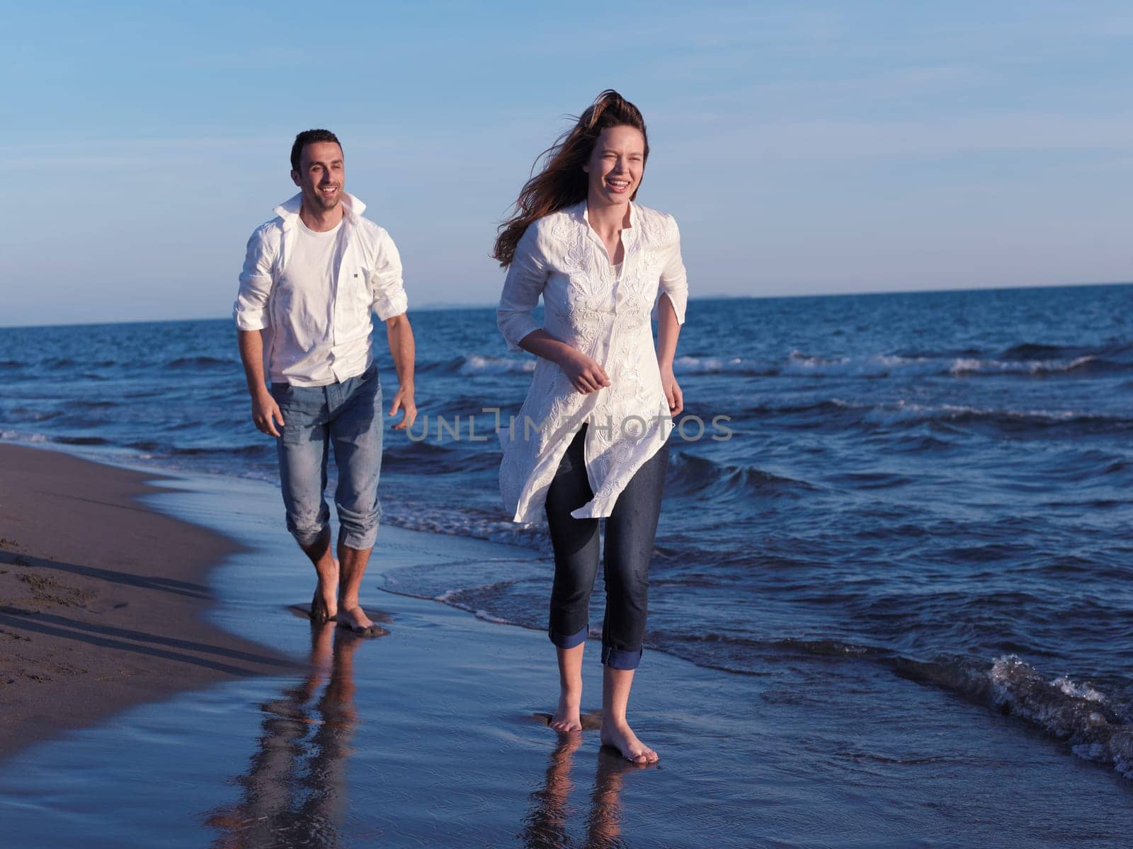 happy young romantic couple in love have fun on beautiful beach at beautiful summer day