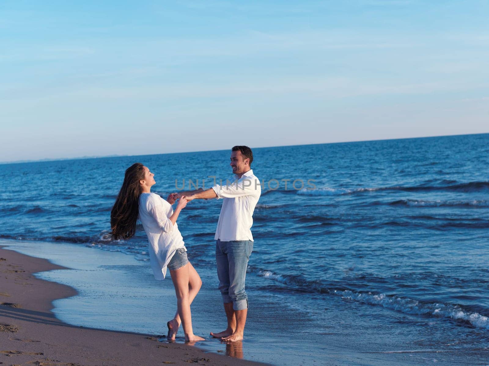 happy young romantic couple in love have fun on beautiful beach at beautiful summer day