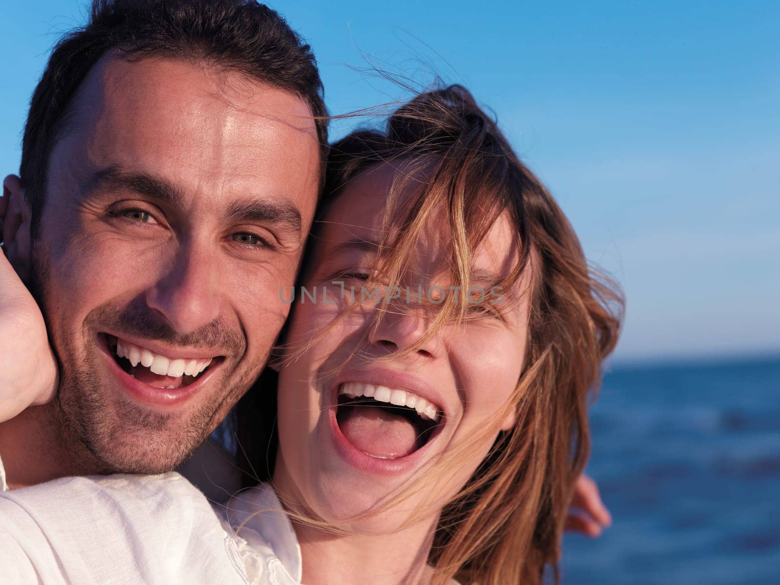 happy young romantic couple in love have fun on beautiful beach at beautiful summer day