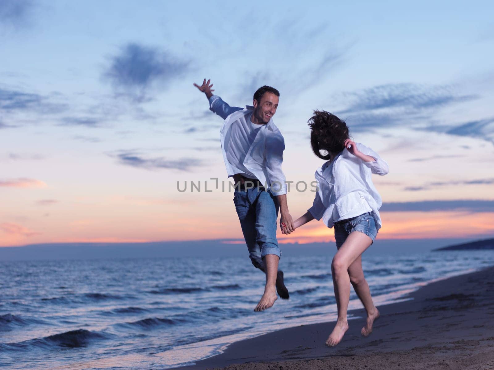 happy young romantic couple in love have fun on beautiful beach at beautiful summer day